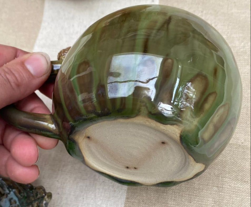 Kleine bosgroene mok met egeltje op de rand