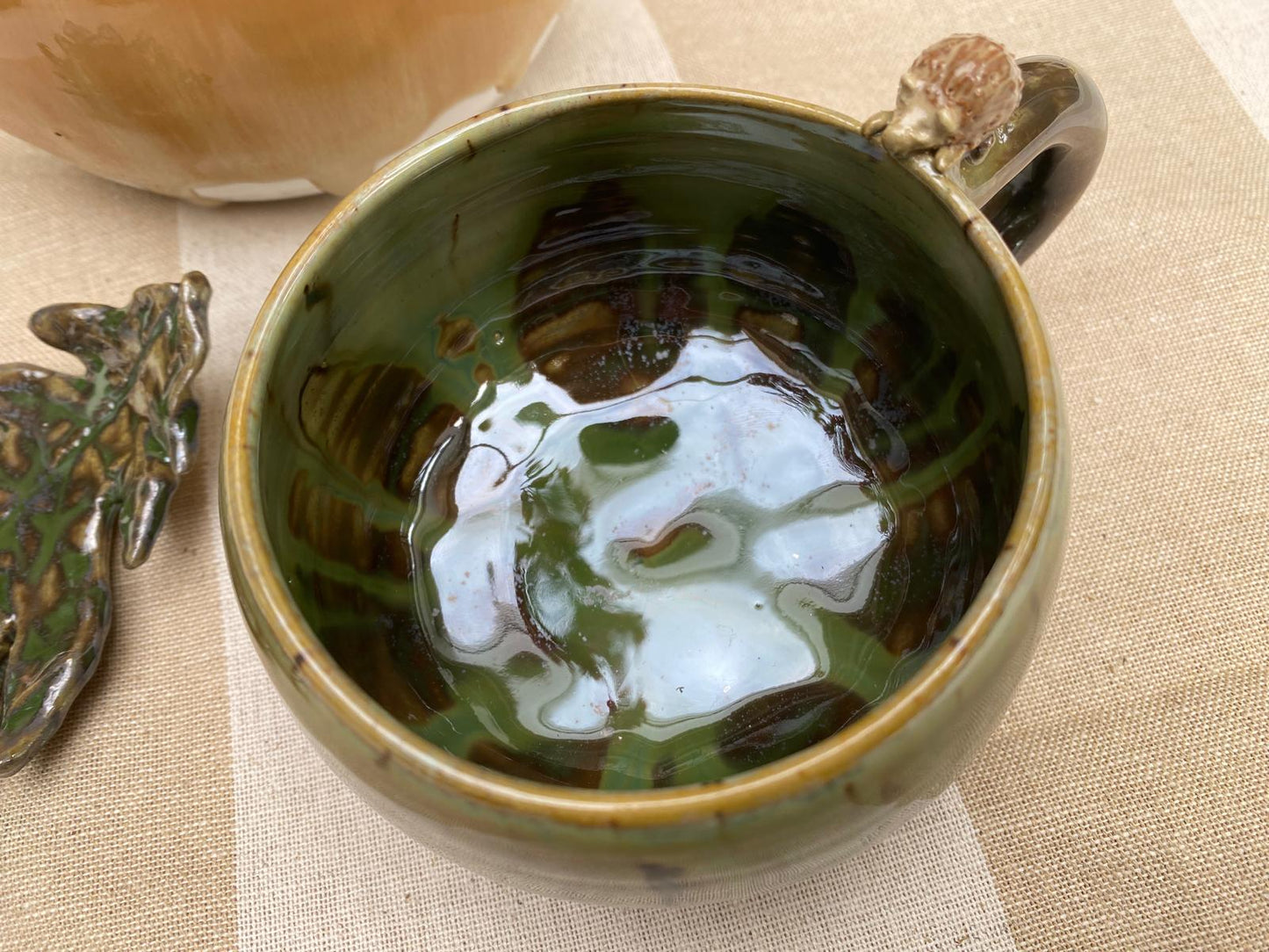 Kleine bosgroene mok met egeltje op de rand