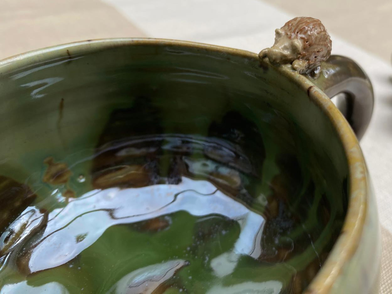 Kleine bosgroene mok met egeltje op de rand