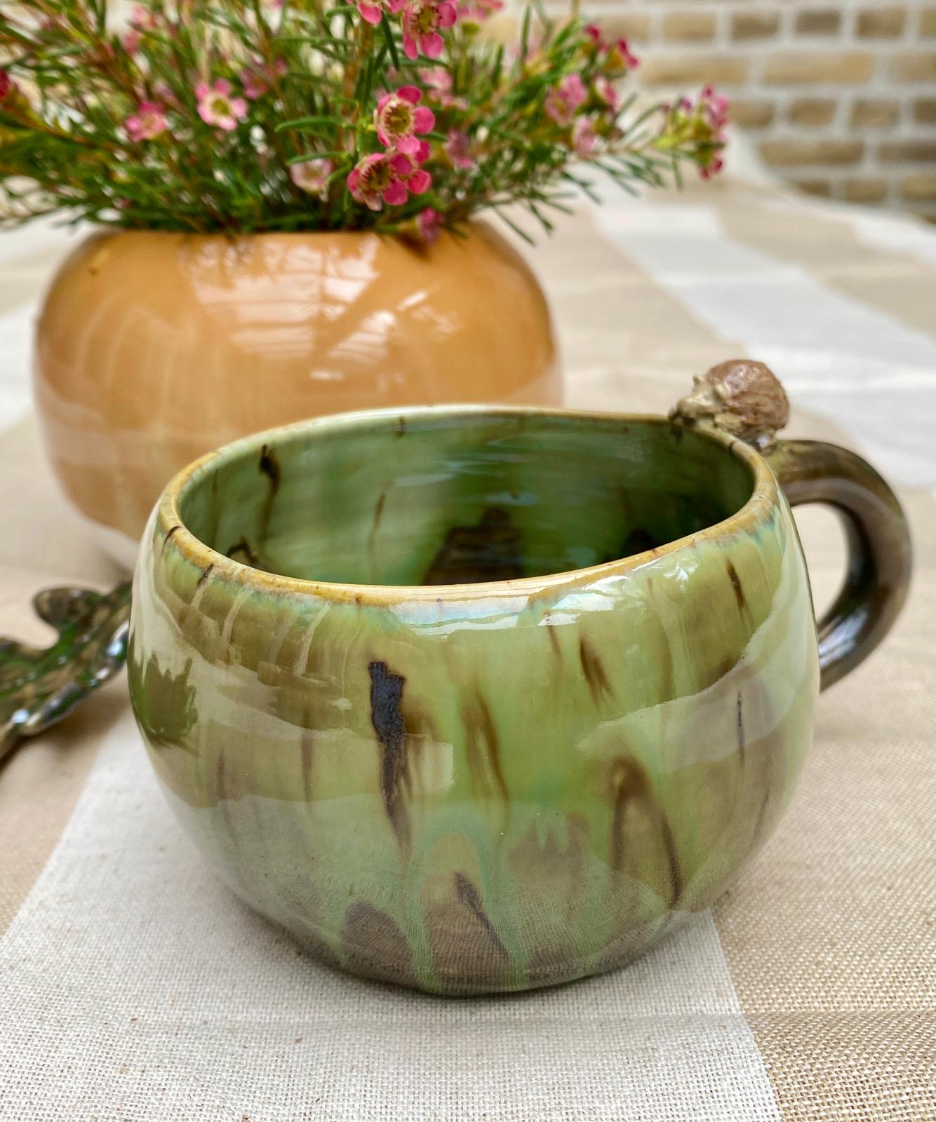 Kleine bosgroene mok met egeltje op de rand